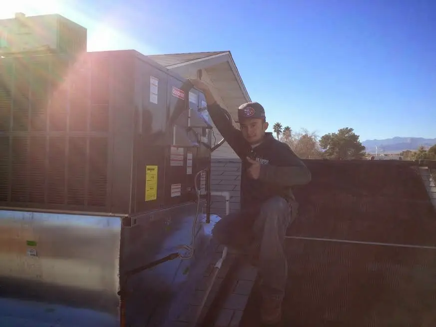 HVAC technician performing AC Tune-Up on a rooftop unit in Lecanto